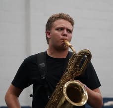 Caden playing saxophone in a black T-shirt