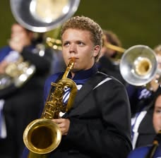 Caden in marching band uniform playing saxophone